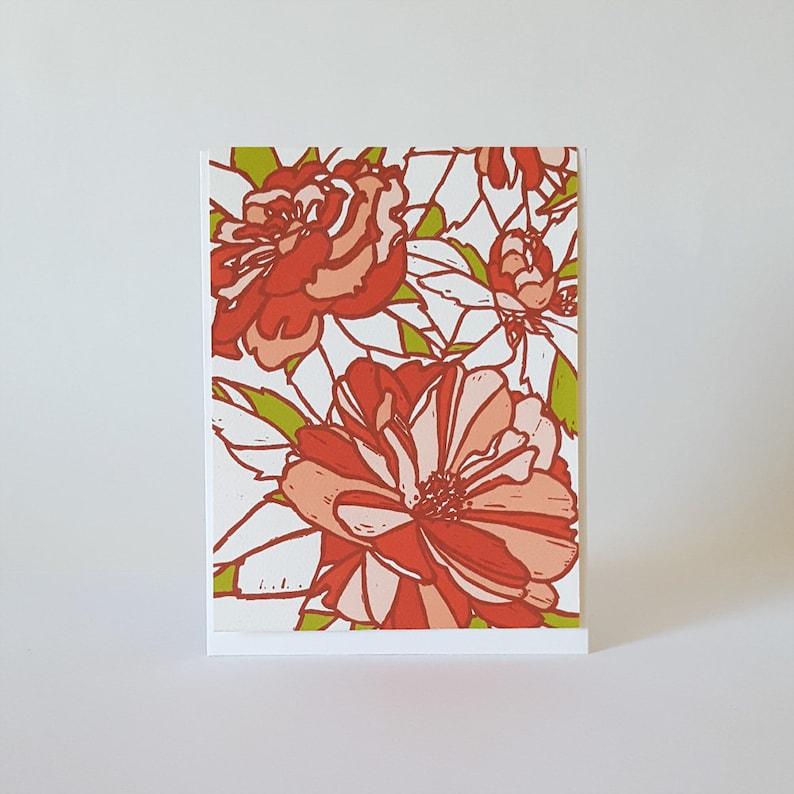 May include: A greeting card with a floral design featuring red and pink flowers with green leaves on a white background.