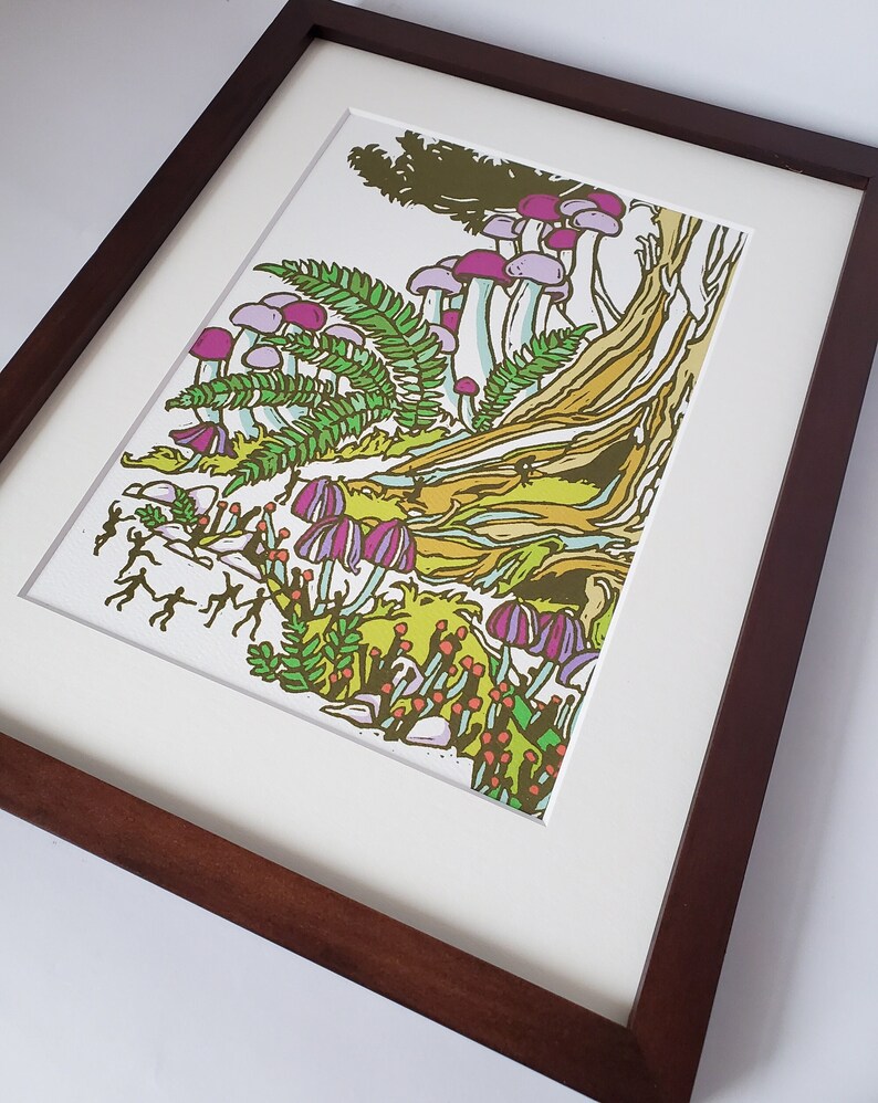 May include: A framed print of a colorful illustration featuring a forest scene with mushrooms, ferns, and small figures. The mushrooms are purple and white, and the ferns are green. The figures are small and white, and they are walking through the forest.