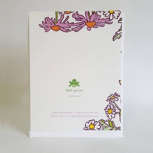 May include: A white card with a green frog logo that says "little green" and "yellow rose". The card has a border of pink and white flowers. The text on the card reads "100% recycled paper - made in Tacoma, WA &copy;2017 / BK-12 - www.littlegreencards.com"