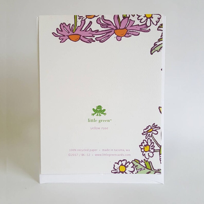 May include: A white card with a green frog logo that says "little green" and "yellow rose". The card has a border of pink and white flowers. The text on the card reads "100% recycled paper - made in Tacoma, WA &copy;2017 / BK-12 - www.littlegreencards.com"