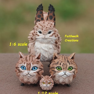 May include: A collection of four cat-like figurines with brown striped fur. One large creature has tall, spotted ears. Three smaller, rounder cat figures feature bright blue, green, and yellow eyes. Text reads 1:6 scale, 1:12 scale, and Faithwalk Creations.