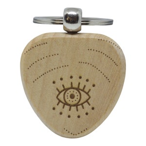 May include: A wooden keychain in the shape of a guitar pick with a laser-etched eye design. The keychain is light brown and has a silver metal ring.