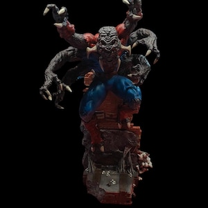 May include: A multi-armed, monstrous figure with a red and blue costume, standing on a broken brick wall. The figure has a grotesque, detailed face and multiple arms with sharp claws.