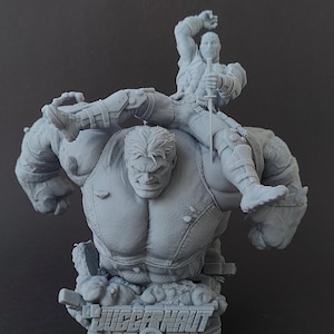 Pode incluir: Uma escultura cinzenta impressa em 3D com duas personagens de banda desenhada. Uma &eacute; grande e musculosa, com uma express&atilde;o zangada. A outra &eacute; mais pequena, segurando uma espada. A base da escultura tem a palavra "JUGGERNAUT" e o texto "Example print".