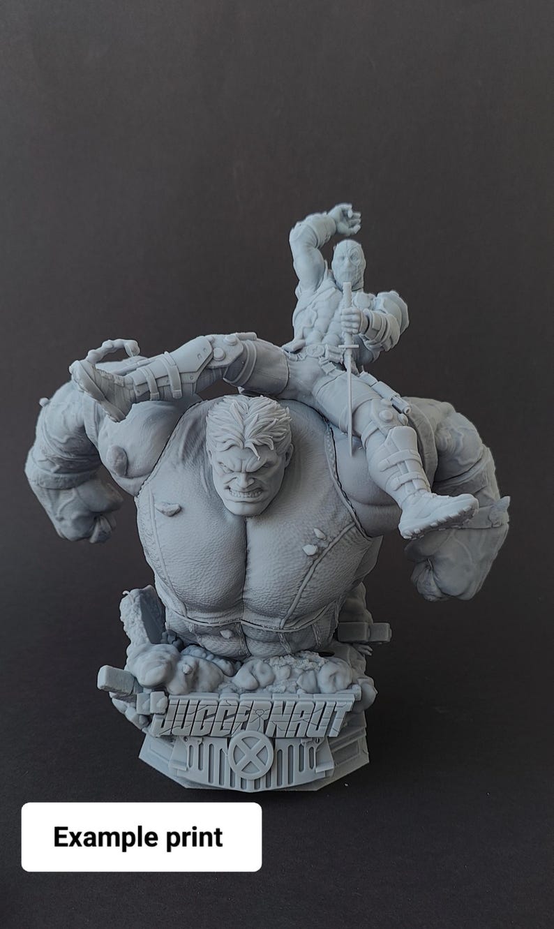 Pode incluir: Uma escultura cinzenta impressa em 3D com duas personagens de banda desenhada. Uma &eacute; grande e musculosa, com uma express&atilde;o zangada. A outra &eacute; mais pequena, segurando uma espada. A base da escultura tem a palavra "JUGGERNAUT" e o texto "Example print".