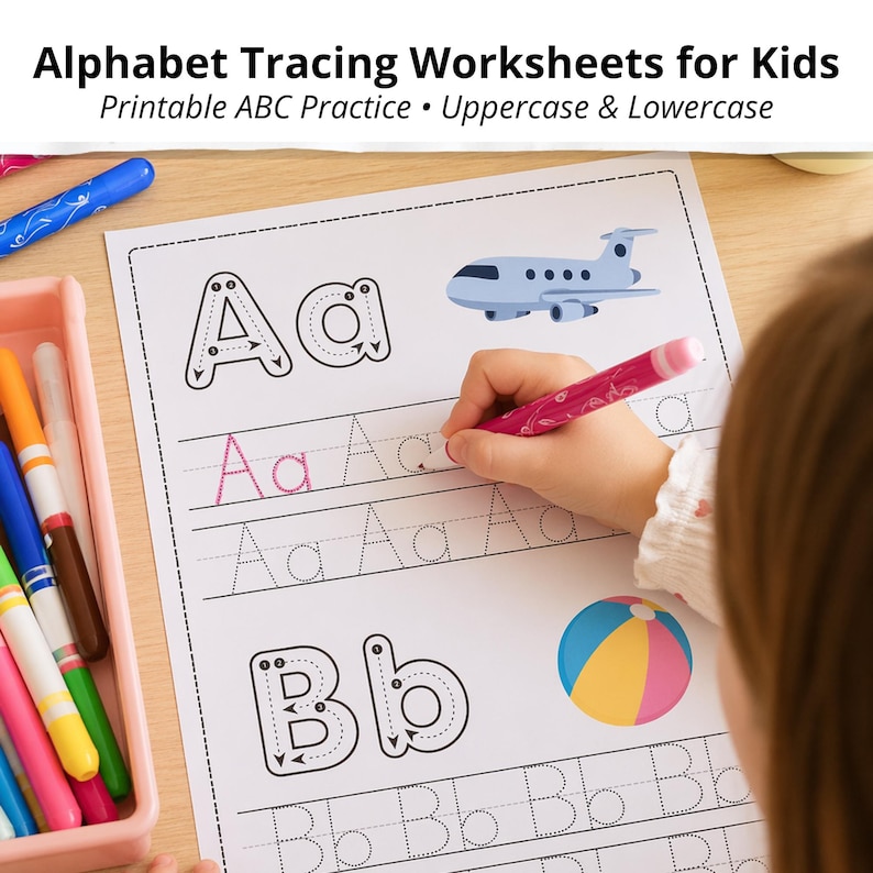 May include: Alphabet tracing worksheet for children featuring uppercase and lowercase letters. The worksheet includes the letters A and B, with illustrations of an aeroplane and a beach ball. A child's hand is using a pink pen to trace the letter A.