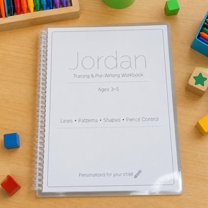May include: A spiral-bound workbook with the name "Jordan" on the cover. The workbook is designed for tracing and pre-writing practice for ages 3-5. The cover also lists lines, patterns, shapes, and pencil control as learning areas.
