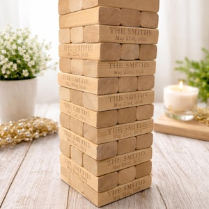 May include: A white ceramic mug with a black handle and the text "But First, Coffee" in a bold, black font. The mug is filled with a dark liquid, likely coffee, and sits on a light-colored surface.