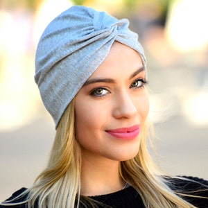 The model is wearing a turban style hat sewn from silver jersey fabric.