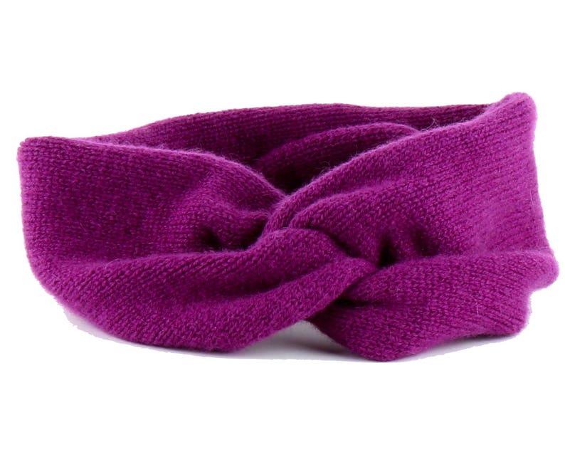 May include: A purple knitted headband with a twisted design.