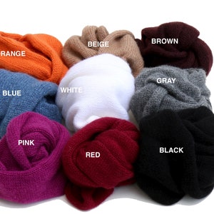 May include: Ten different colored knitted scarves in a variety of colors including orange, beige, brown, gray, white, pink, red, black, and blue.