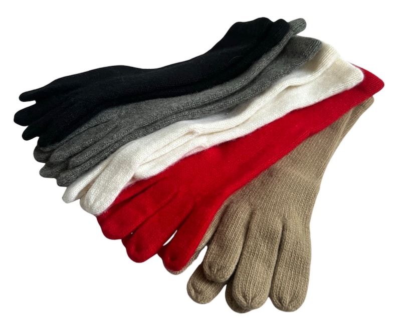 May include: A stack of five pairs of long fingerless gloves in various colors, including black, gray, white, red, and beige.
