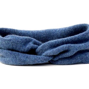 May include: A blue knitted headband with a twisted knot design.
