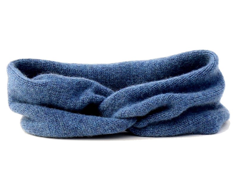 May include: A blue knitted headband with a twisted knot design.