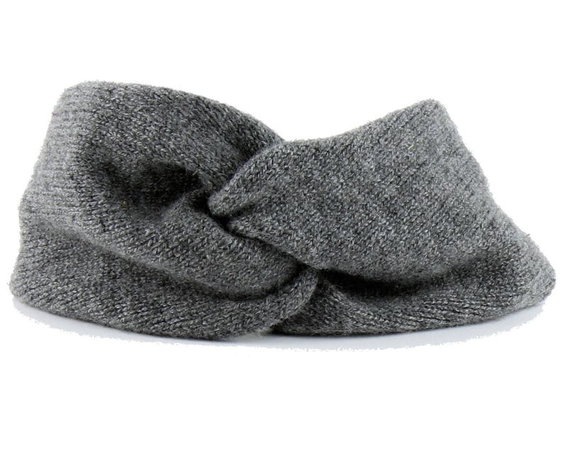 May include: A gray knitted headband with a twisted knot design.