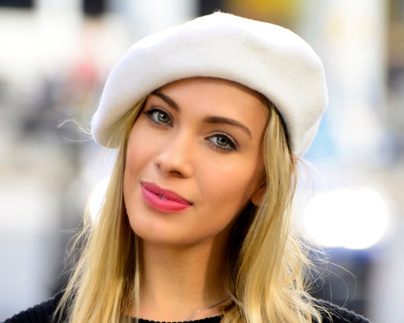 The model is wearing a white wool beret.