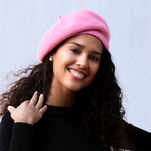 The model is wearing a pink wool beret.