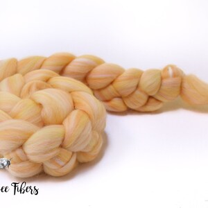 Puede incluir: Una trenza de hilo de lana de color naranja claro y blanco. El hilo est&aacute; trenzado de forma suelta y relajada. El hilo es suave y esponjoso, y ser&iacute;a perfecto para tejer o hacer ganchillo.