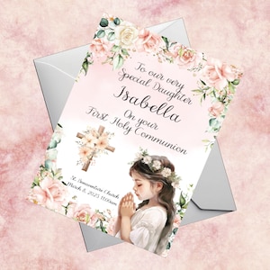Puede incluir: Una tarjeta de Primera Comunión con un diseño de acuarela. La tarjeta presenta el texto "To our very Special Daughter Isabella On your First Holy Communion". También se representa una cruz floral y una niña rezando.