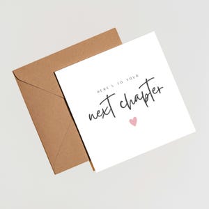 Könnte beinhalten: Eine weiße Grußkarte mit dem Text "Here's to your next chapter" in schwarzer Schrift, begleitet von einem kleinen rosa Herz. Die Karte wird mit einem braunen Umschlag kombiniert, wodurch ein schlichtes und elegantes Design entsteht.