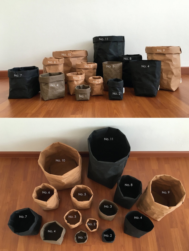 Puede incluir: Un conjunto de 11 bolsas de papel marr&oacute;n con forros de tela negra, numeradas del 1 al 11. Las bolsas est&aacute;n dispuestas en dos filas, con las bolsas m&aacute;s grandes en la parte posterior y las m&aacute;s peque&ntilde;as en la parte delantera. Las bolsas est&aacute;n todas vac&iacute;as.