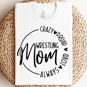 May include: White t-shirt with a black circle design that says "Crazy Proud Wrestling Mom Always Loud".