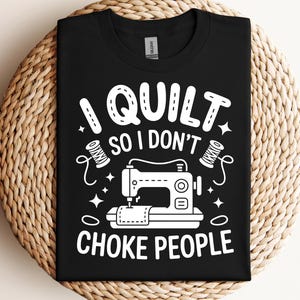 Puede incluir: Camiseta negra con un diseño blanco que dice "I QUILT SO I DON'T CHOKE PEOPLE". El diseño incluye una máquina de coser, carretes de hilo y estrellas. La camiseta se muestra sobre una superficie tejida.