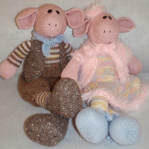 May include: Two knitted pig toys, one brown with a striped vest and blue scarf, the other pink with a pink and yellow striped dress and a pink fluffy jacket.