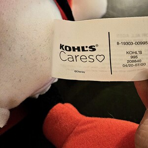 Puede incluir: Peluche blanca y roja con boca y ojos negros. El juguete tiene una etiqueta que dice "KOHL'S Cares" con un s&iacute;mbolo de coraz&oacute;n y "&copy;Disney". La etiqueta tambi&eacute;n incluye el n&uacute;mero "8-19303-00995", "KOHL'S 995 208840 04/20-07/20".