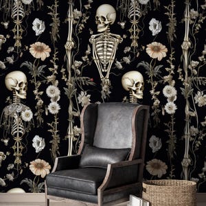 May include: Black wallpaper featuring a repeating pattern of human skeletons, flowers, and vines. The skeletons are depicted in a detailed, anatomical style. The flowers are white and beige, creating a gothic, yet elegant aesthetic. A black leather armchair and a woven basket are in the foreground.