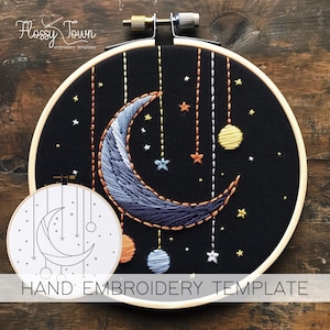 Peut inclure: Un cerceau de broderie noir avec un motif de croissant de lune et d'étoiles. La lune est bleue et violette et a quelques ornements suspendus. Le cerceau est sur une surface en bois. "MODÈLE DE BRODERIE À LA MAIN" est écrit sous le cerceau.