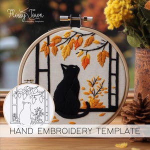 Puede incluir: Plantilla de bordado a mano con un gato negro sentado junto a una ventana con hojas de oto&ntilde;o. La plantilla incluye un gato negro, una ventana con una escalera y hojas de oto&ntilde;o en tonos amarillos y naranjas. La plantilla est&aacute; sobre un fondo de tela blanco.