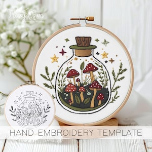 May include: A hand embroidery template featuring a glass bottle filled with mushrooms and greenery. The template is printed on white fabric and is ready to be stitched.