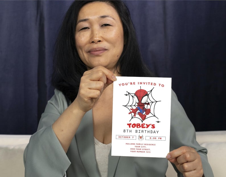 May include: A white invitation card with a red and blue cartoon Spiderman character in a web. The text on the card reads "You're invited to Tobey's 8th Birthday, October 7, 5:00 PM, Hollands Family Residence, Your City, Your Street, Your Number 2023."