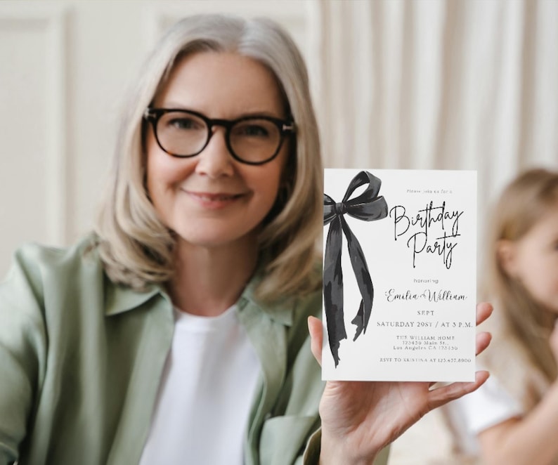 May include: A white invitation card with a black bow and the words "Birthday Party" in elegant script. The card also includes event details such as the date, time, and names "Emilia & William".