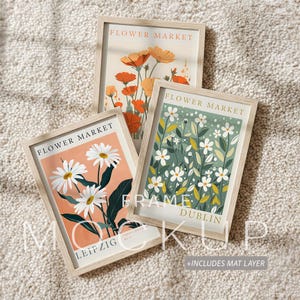 Op de afbeelding: Drie ingelijste bloemenkunstprints. De prints tonen illustraties van bloemen in oranje, witte en groene tinten. Elke lijst heeft een lichte houten afwerking en de tekst "FLOWER MARKET" is zichtbaar op elke print. De onderste print luidt "LEIPZIG".