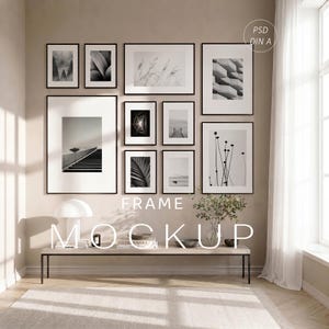 May include: A gallery wall arrangement featuring ten black-framed prints in various sizes displaying black and white photography. The collection is displayed above a long, thin bench with a white lamp, books, and a small plant in a glass vase.