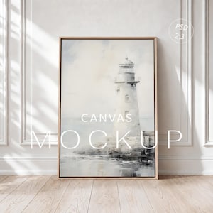 May include: A vertical rectangular canvas print in a light wood frame featuring a monochromatic painting of a lighthouse on a rocky shore. The artwork displays soft gray and white tones. The text "CANVAS MOCKUP" and "PSD 2:3" are visible.