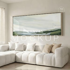 May include: A large rectangular canvas mockup with a landscape painting in shades of green, grey, and white, framed in a light wood. The text "CANVAS MOCKUP" is overlaid on the painting. A white sectional sofa with pillows is in the foreground.