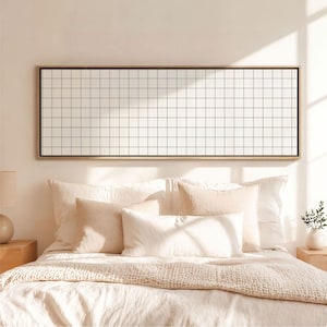 May include: A rectangular wall art piece featuring a black grid pattern on a white background, enclosed in a thin wooden frame. The artwork is displayed horizontally, showcasing a repeating square grid design that spans the entire length of the frame.
