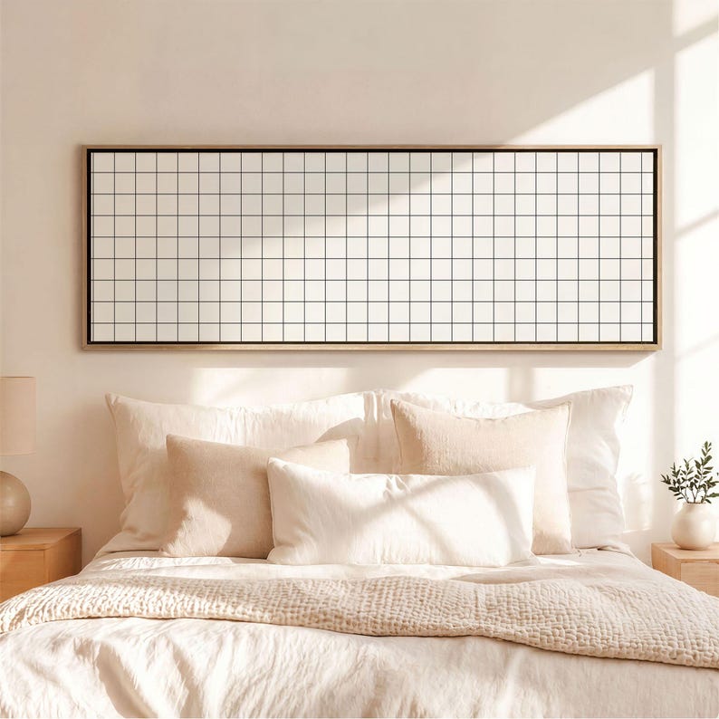 May include: A rectangular wall art piece featuring a black grid pattern on a white background, enclosed in a thin wooden frame. The artwork is displayed horizontally, showcasing a repeating square grid design that spans the entire length of the frame.