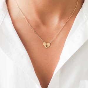 woman wearing necklace with heart shape pendant