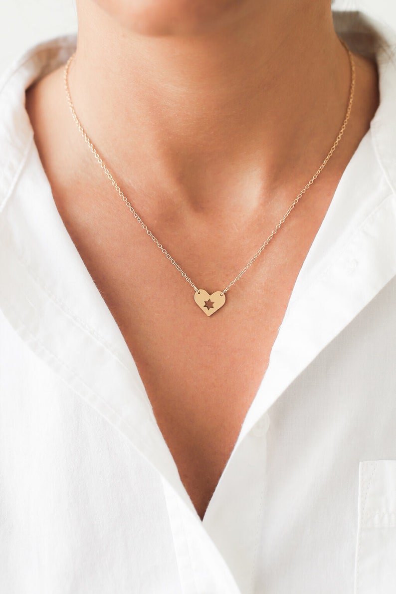 woman wearing necklace with heart shape pendant