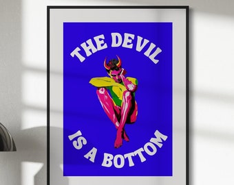 May include: A framed print with a blue background and white text that reads "THE DEVIL IS A BOTTOM". A pink and yellow illustration of a devil with horns sits in the center of the print.