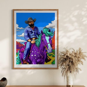 May include: A framed art print featuring a cowboy riding a purple horse with a starry pattern. The cowboy wears a blue shirt and hat, set against a desert landscape with a blue sky and clouds. The artwork has vibrant colors and a pop art style.