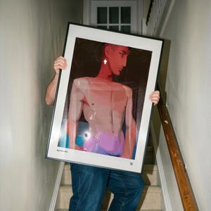Puede incluir: Una impresión de arte digital enmarcada que presenta una ilustración estilizada de una persona con cabello corto, mandíbula definida y torso desnudo. La obra utiliza una paleta de tonos marrón oscuro, rosa suave y azul brillante. El texto @penduworks es visible.