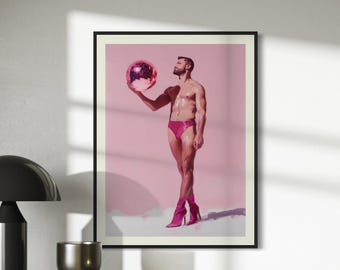 May include: A man in pink swim trunks and pink boots holds a pink disco ball in front of a pink background.