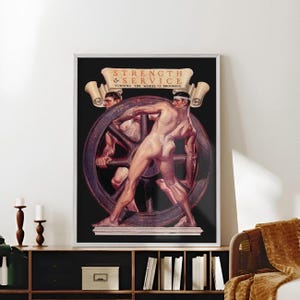 Pode incluir: Uma impressão de arte emoldurada com duas figuras nuas empurrando uma grande roda. A obra de arte, em um fundo preto, inclui o texto "STRENGTH & SERVICE" e "TURNING THE WHEEL OF PROGRESS" em uma faixa. A impressão é exibida em uma prateleira de madeira escura.