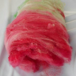 May include: A pile of pink, white, and green wool roving. The wool is soft and fluffy, and it is perfect for spinning or felting.