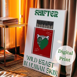 May include: A white framed digital print with the word "SHIFTER" in green. The print features a red rectangle with a leopard design and the text "WILD BEAST IN HUMAN SKIN". A circle with the words "Digital Print" is on the right.